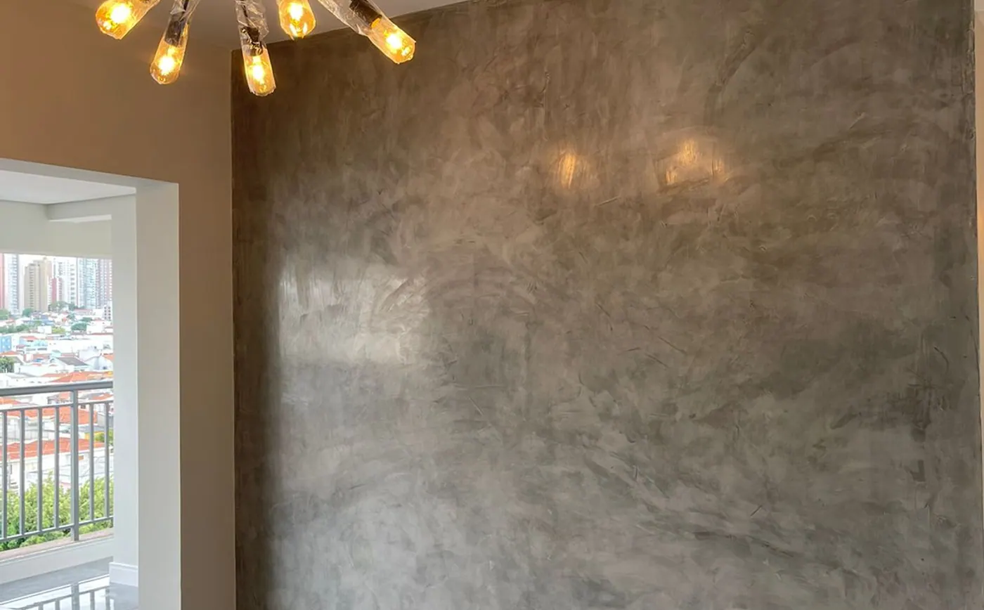 Sala de apartamento com parede em marmorato e luminária pendente